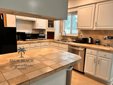 Clean, modern Palm Beach kitchen with tile counters and organized appliances.